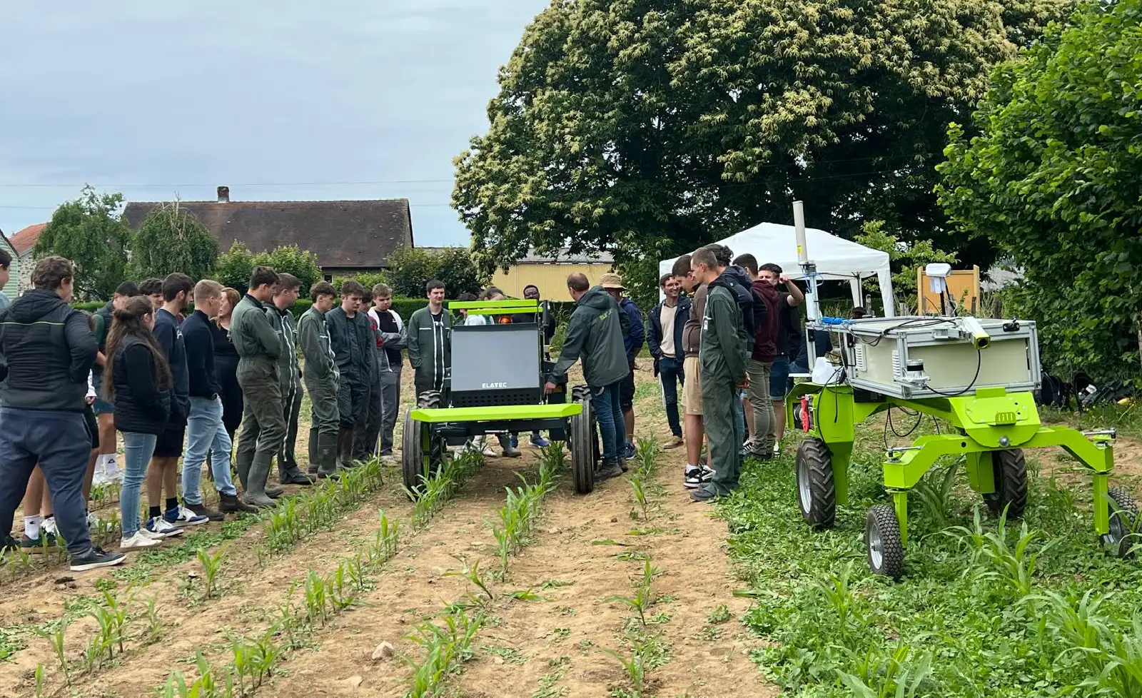 GORT project team and students are looking at the new robot in an open field.