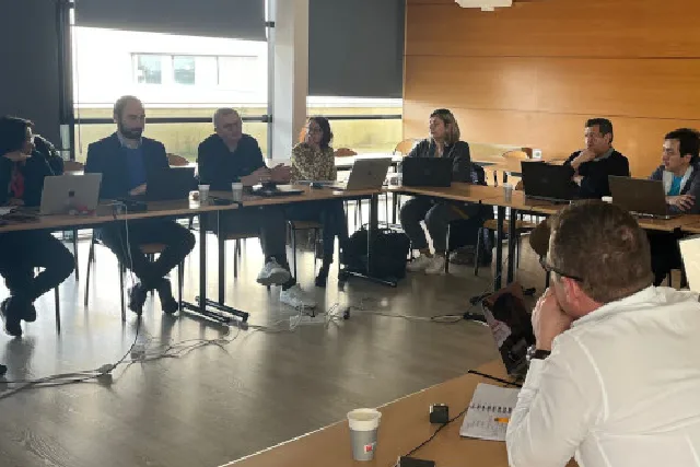 Ten team members of the GORT project team seat in a table during the Kick-off meeting